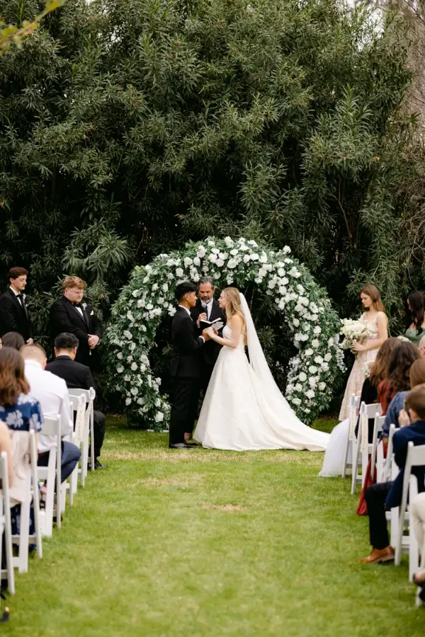 Ceremony in front of a white rose arch